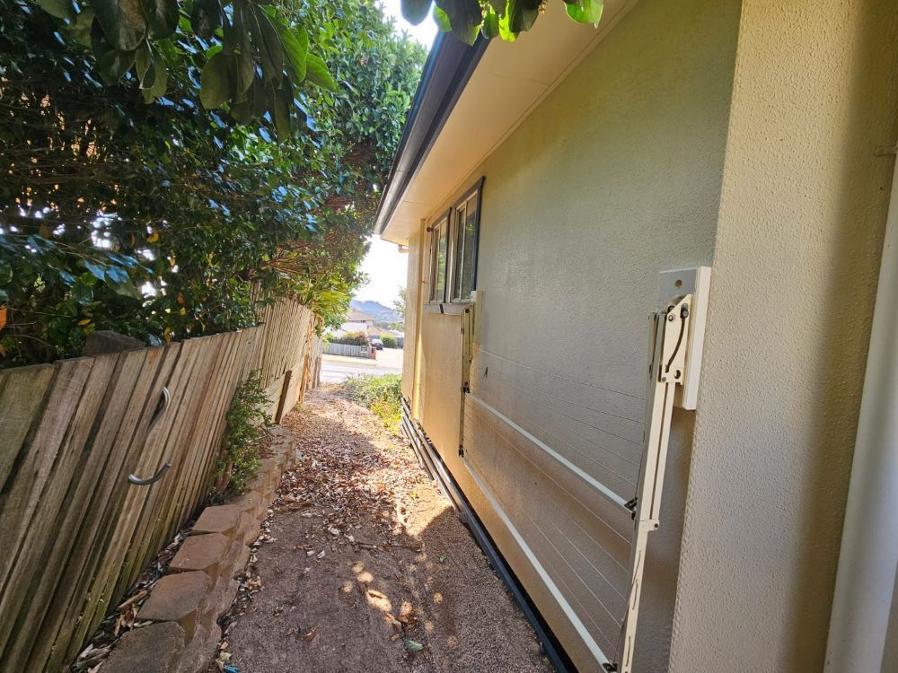A sidewalk leading to a house with a fence in the background. — O & D House Wash & Cleaning Services in Glenvale, QLD
