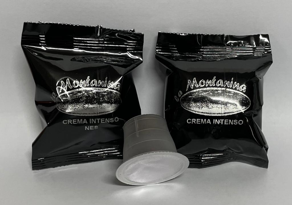Due involucri neri di capsule di caffè con l'etichetta "La Montanina Crema Intenso" e una singola capsula di caffè al centro.