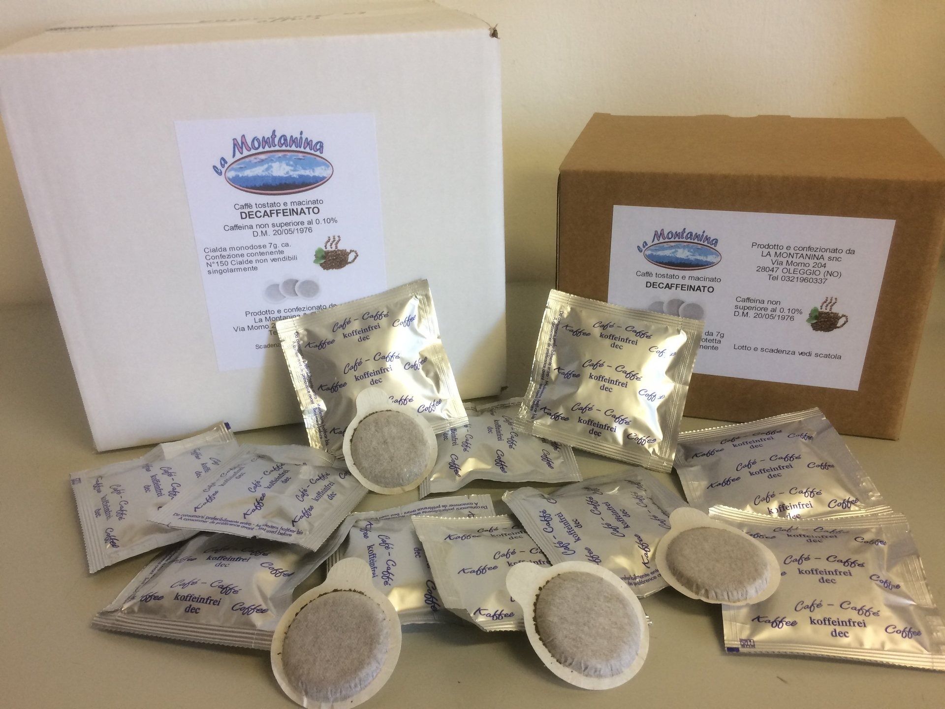 Due scatole di cartone con l'etichetta "Mountain Thunder" circondate da diverse capsule di caffè avvolte singolarmente in fogli di alluminio, disposte su una superficie.