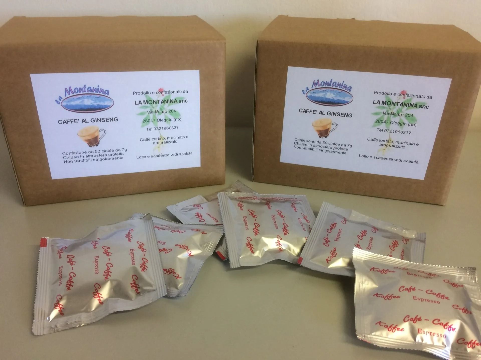 Due scatole di cartone marrone con etichette "Kavalan", accompagnate da diverse piccole bustine monodose di caffè argentate.