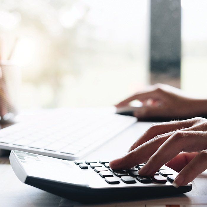 Person Using Computer and Calculator