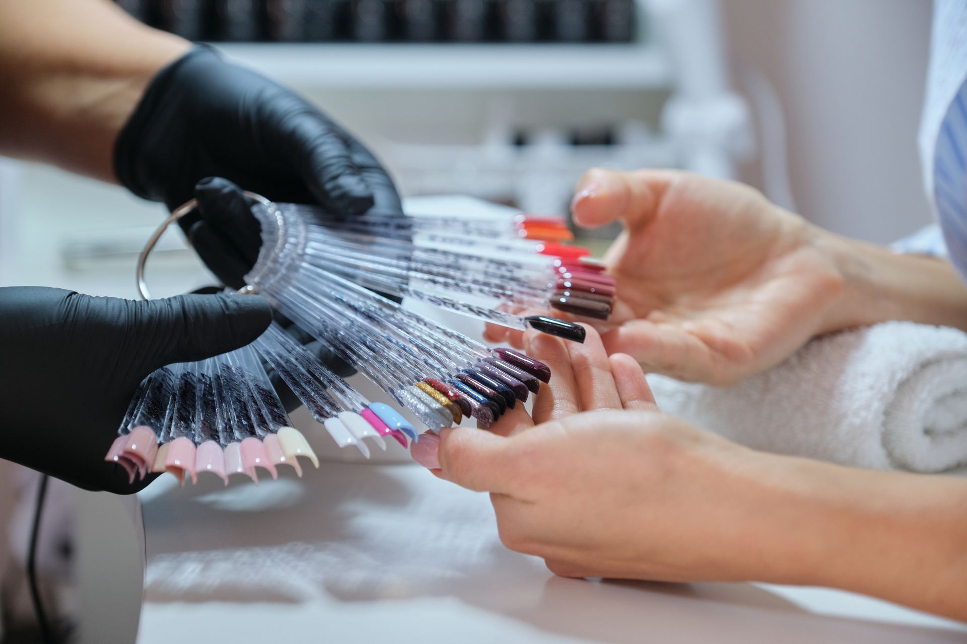 A woman is getting her nails painted by a nail artist.