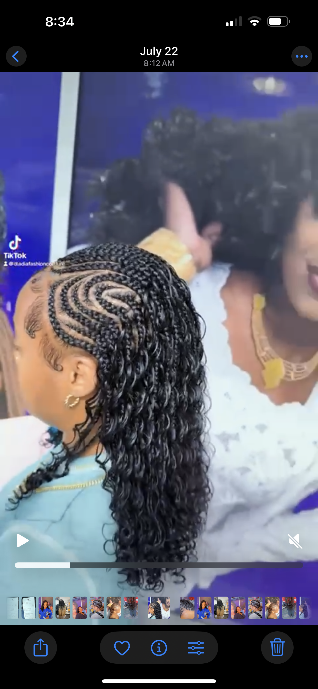 Woman with braided hairstyle, some braids at the top and curly extensions.