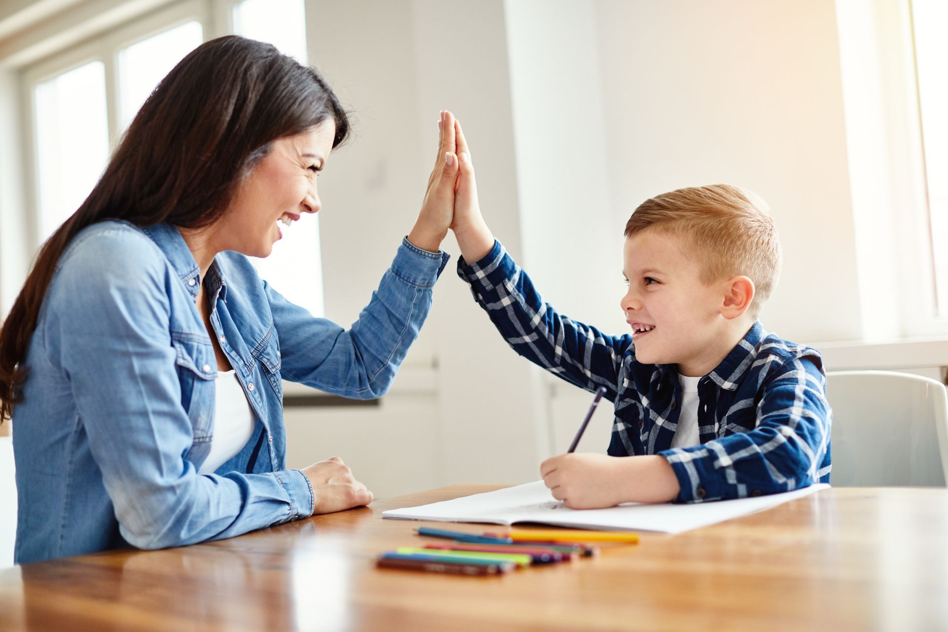 A child is giving a high five to a teacher.