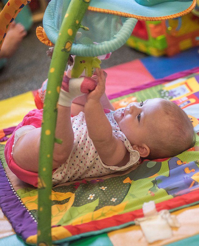 Baby Playing with Hanging Toys — Mokena, IL — Triple R Child Care
