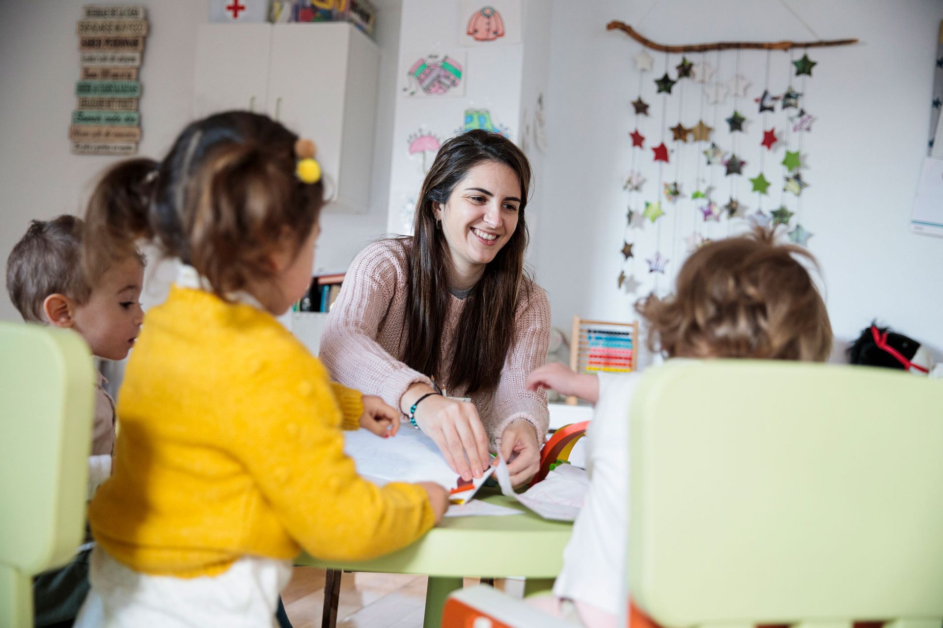 Picture of a kindergarten teacher with her students at school. Picture of a kindergarten teacher with her students at school.