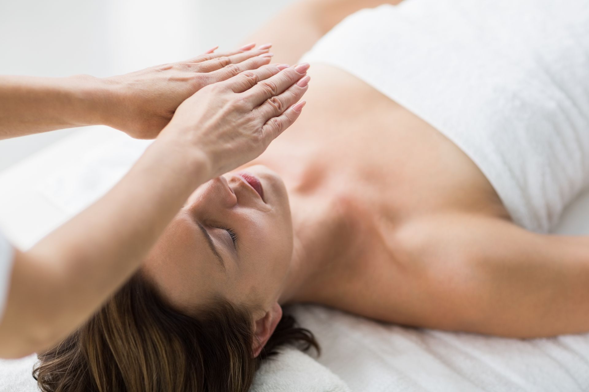 A woman is laying on a bed getting a massage.