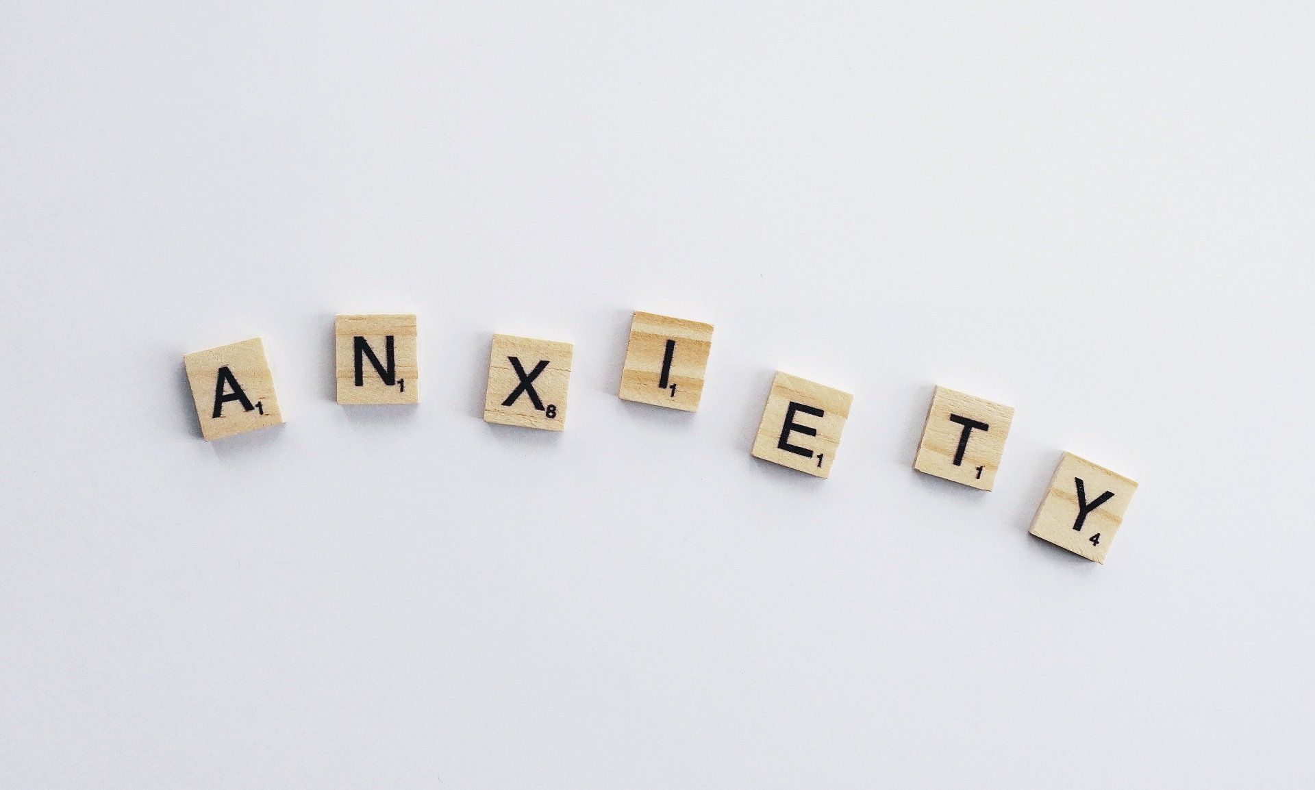 The word anxiety is written in scrabble tiles on a white background.