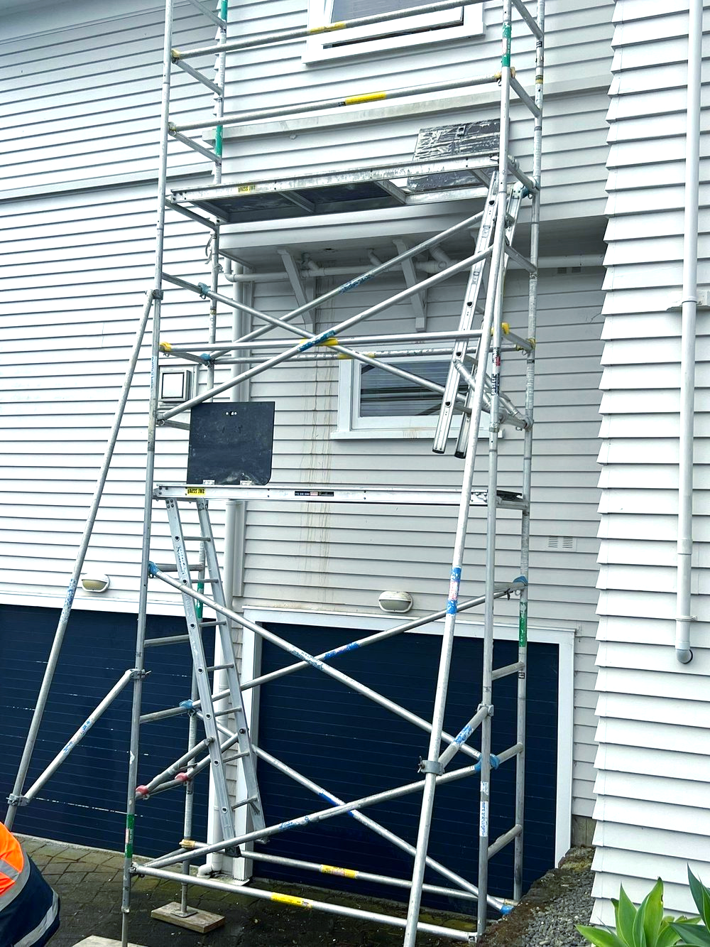 A scaffolding is sitting in front of a white house.