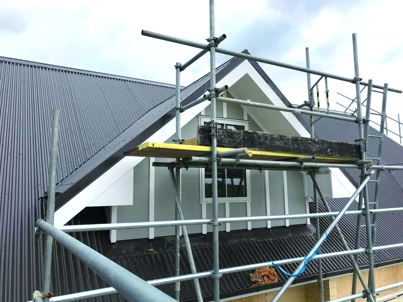 A building with scaffolding on the side of it and a roof.