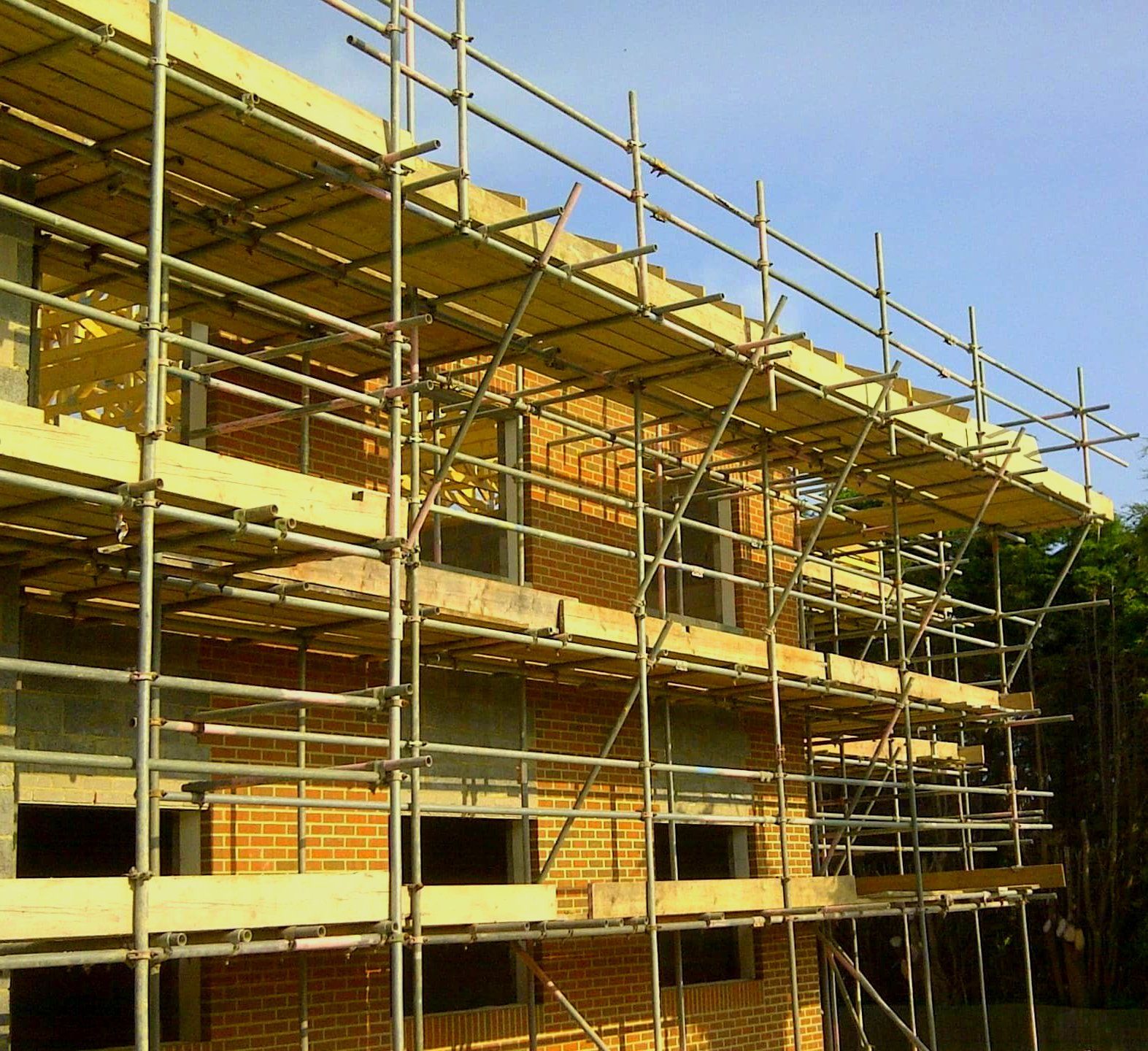 A brick building under construction with scaffolding around it.