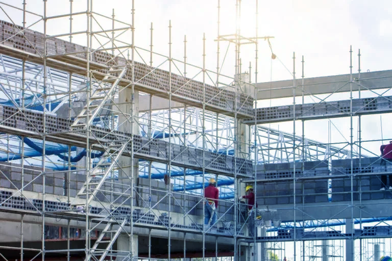 A group of construction workers are working on a building under construction.