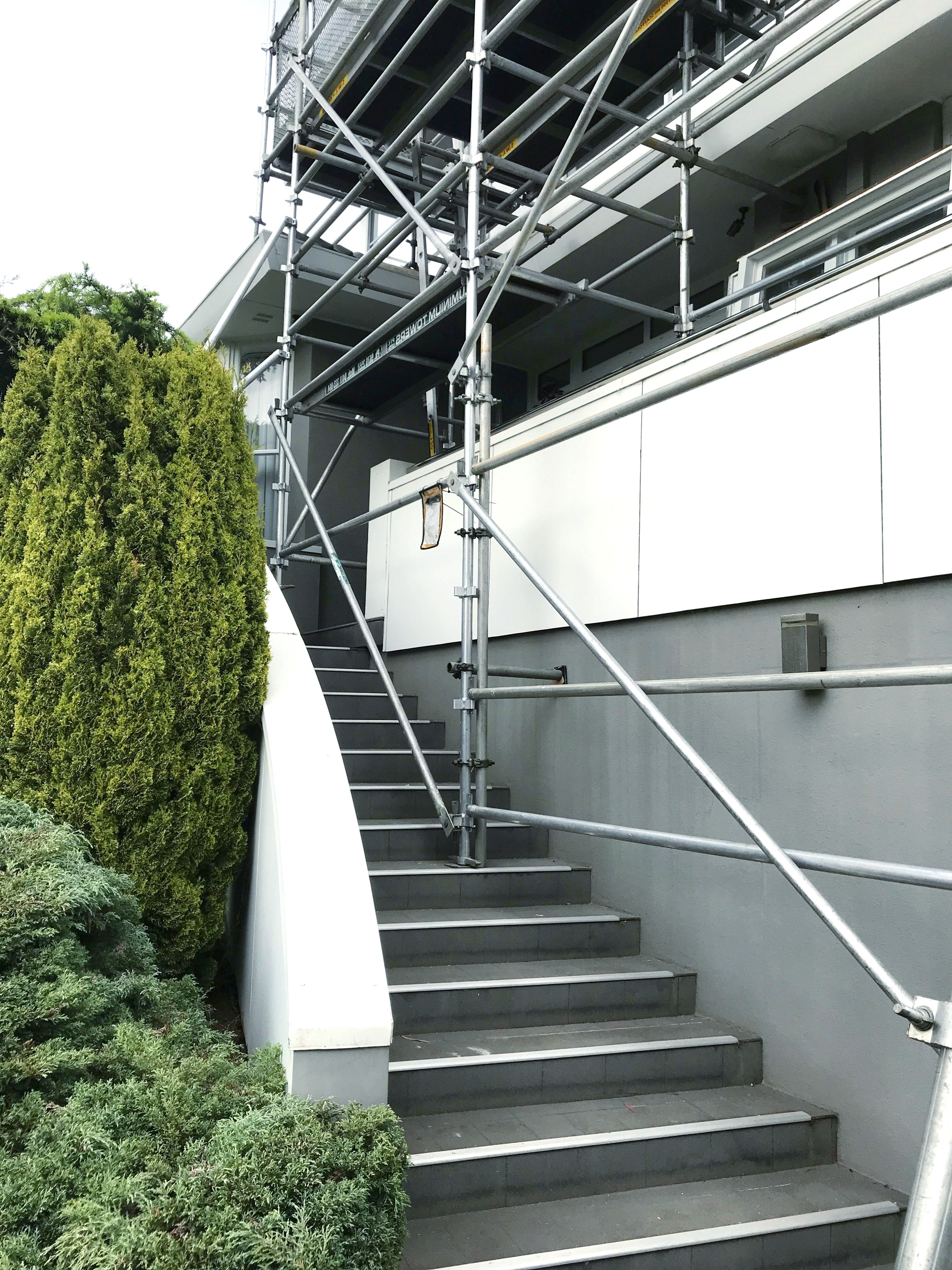 A set of stairs leading up to a building with scaffolding around them.