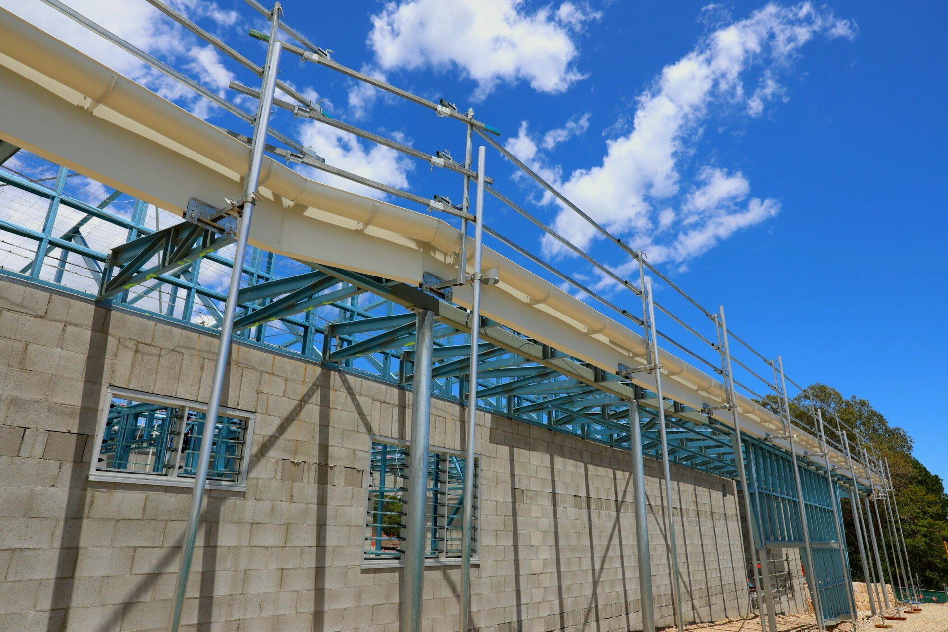 A building under construction with scaffolding and a blue sky in the background.