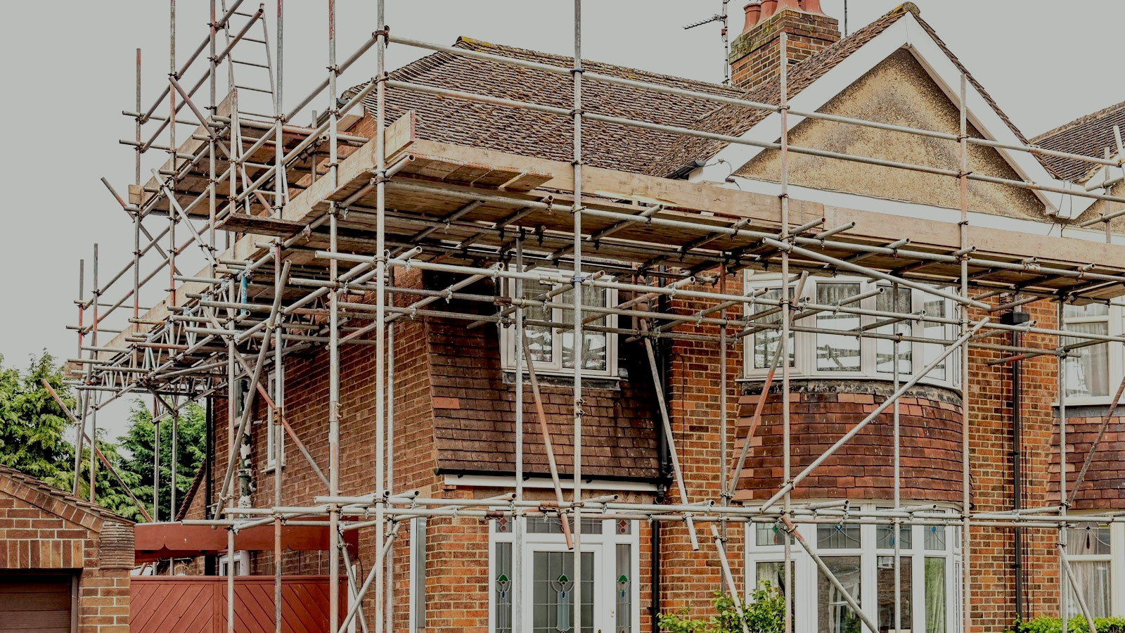 A brick house is being remodeled with scaffolding around it.