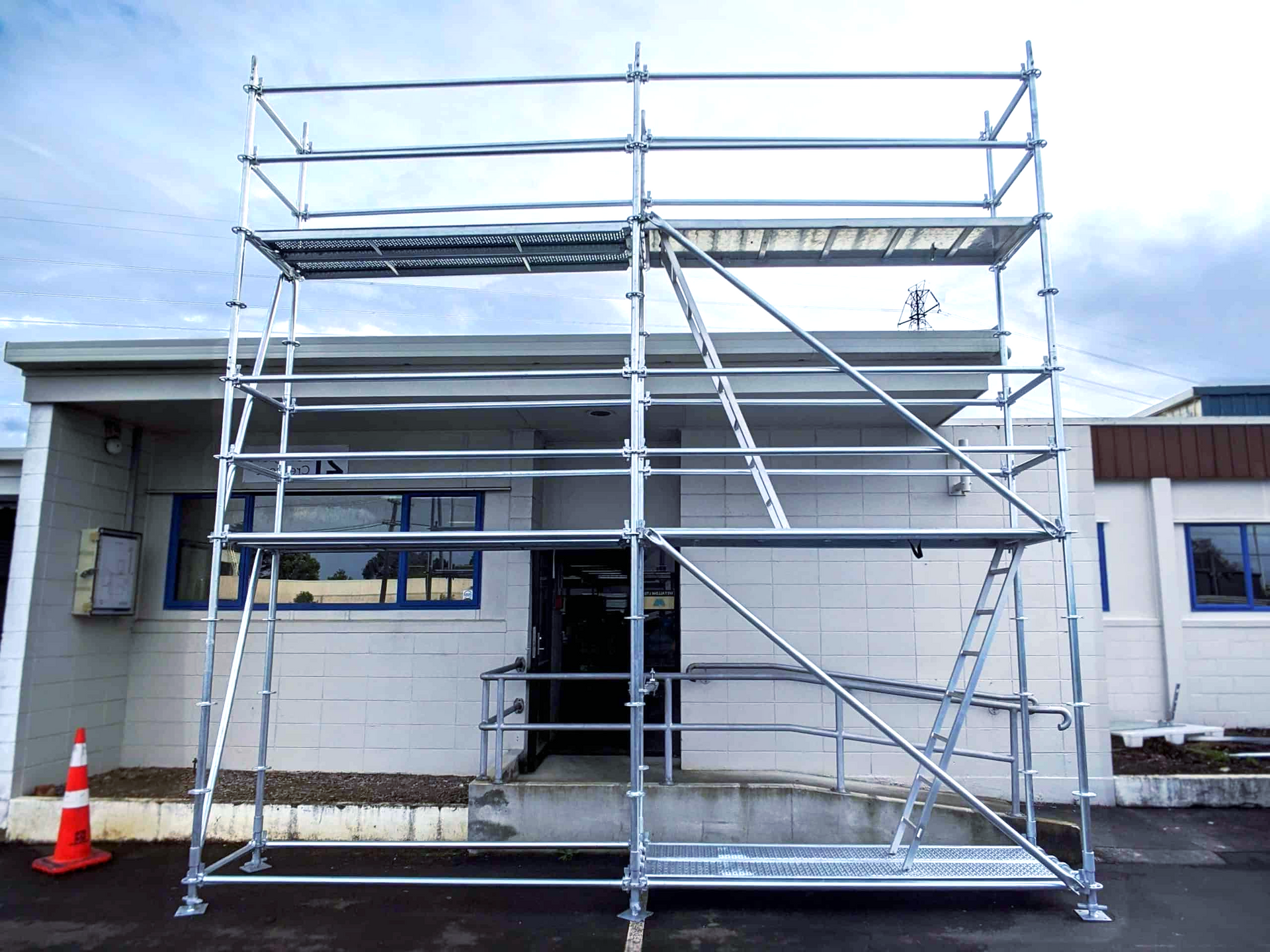 A large metal scaffolding is sitting in front of a building.