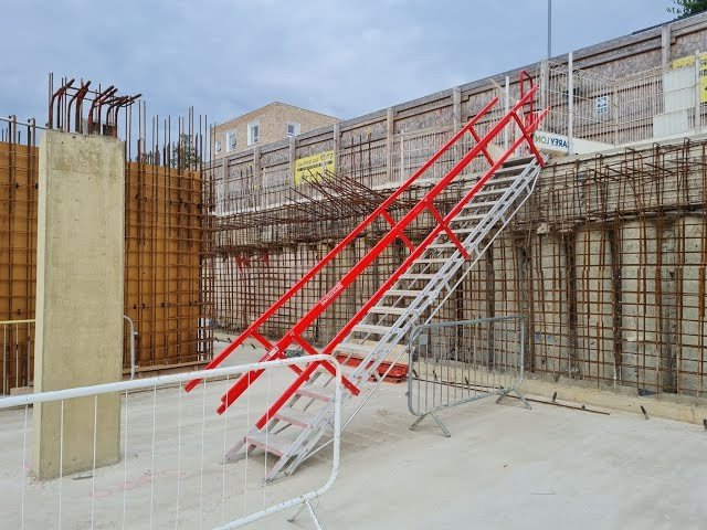 A red and white staircase in a construction site.