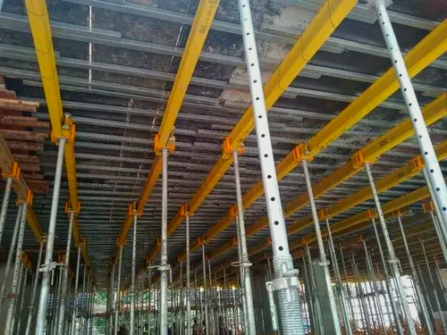 A building under construction with scaffolding supporting its base.