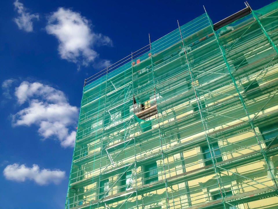 a building is being built with scaffolding and blue sky in the background