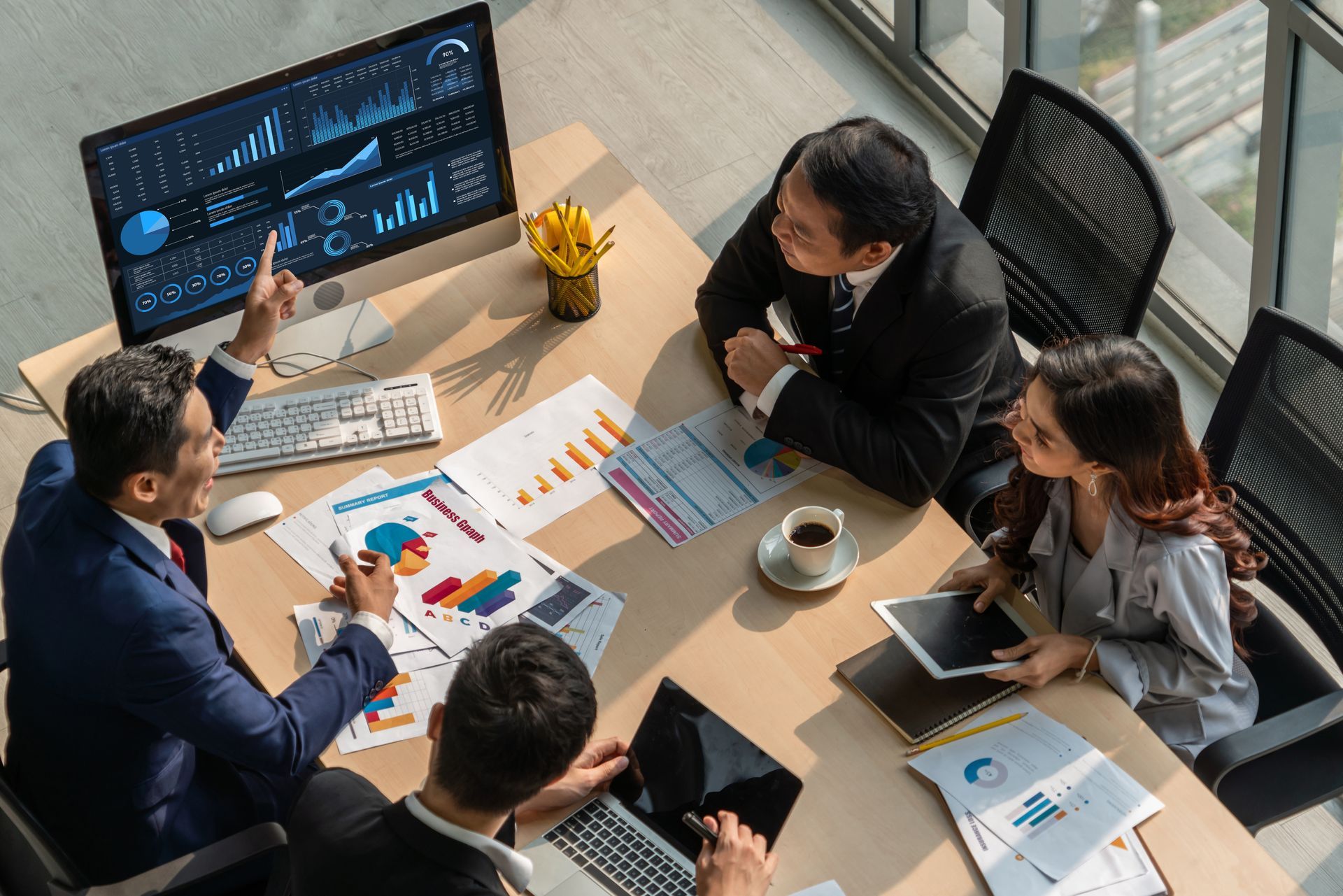 A group of business people are sitting around a table having a meeting.