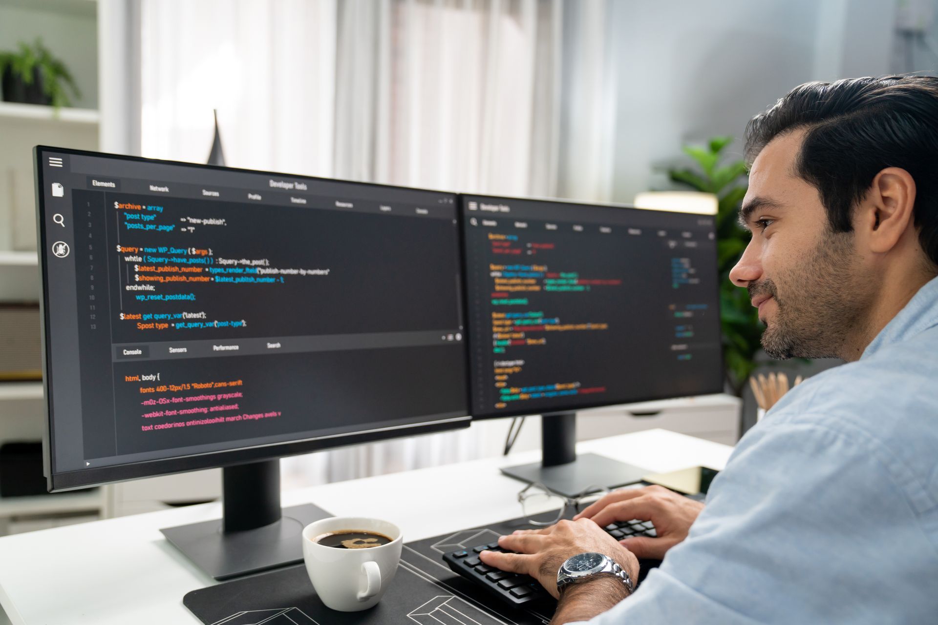 A man is sitting at a desk in front of two computer monitors.