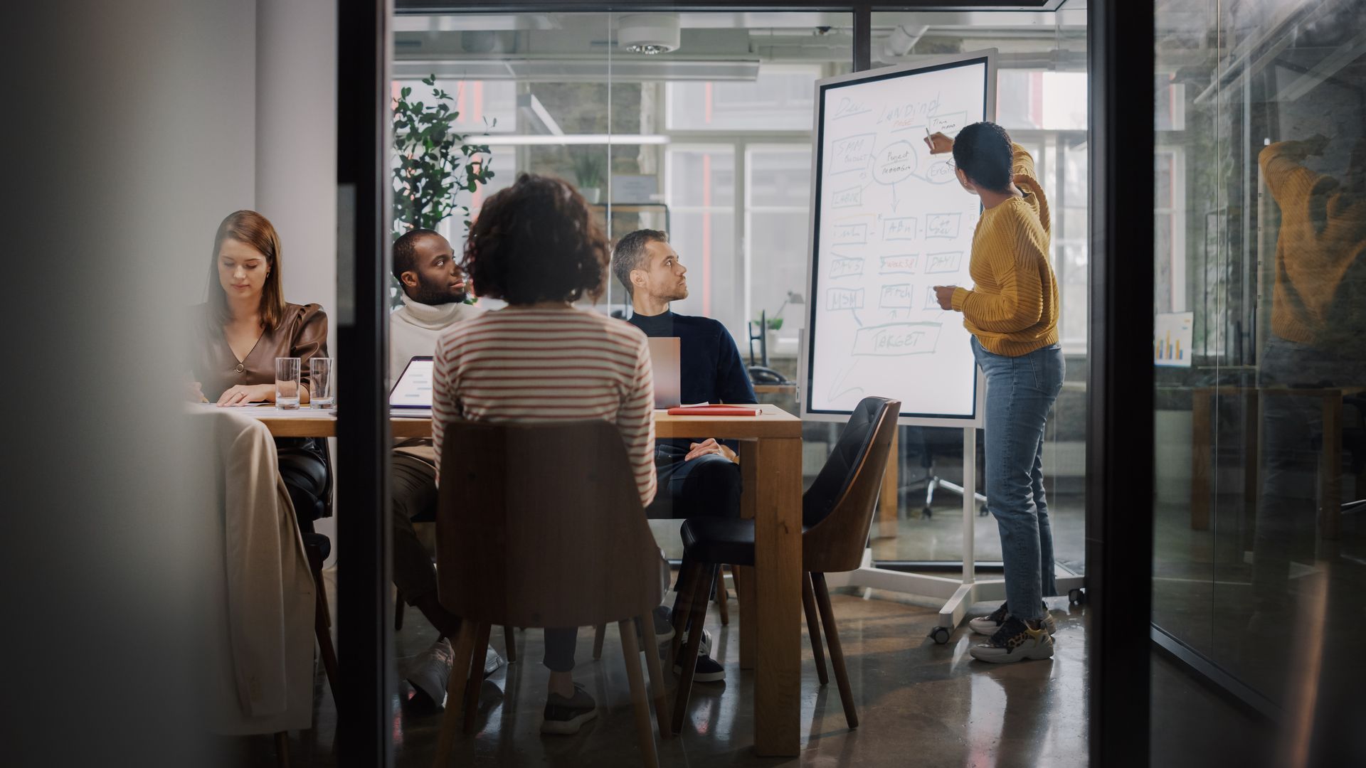 A woman is giving a presentation to a group of people in a conference room.