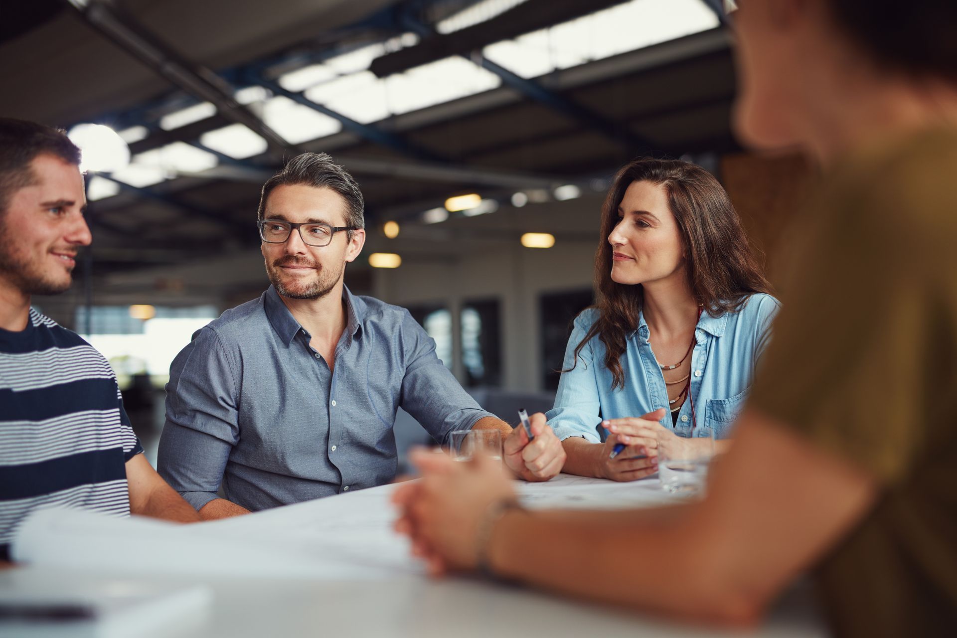 A group of people are sitting around a table having a meeting.