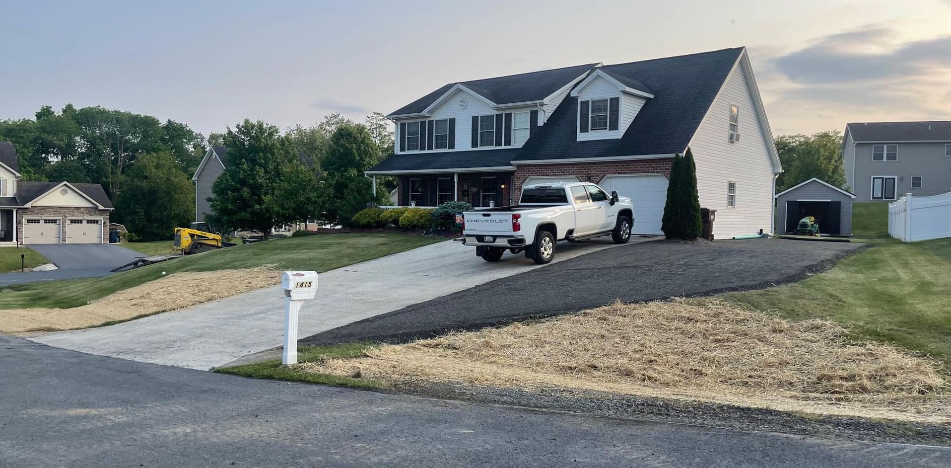 A white truck is parked in front of a house.