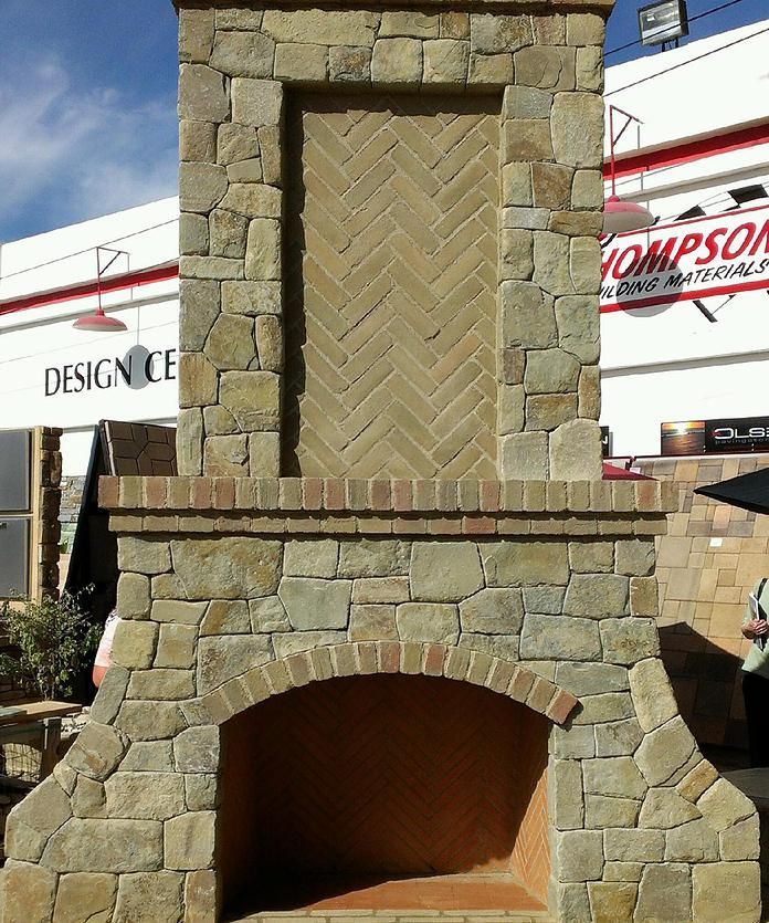 A large stone fireplace in front of a thompson building