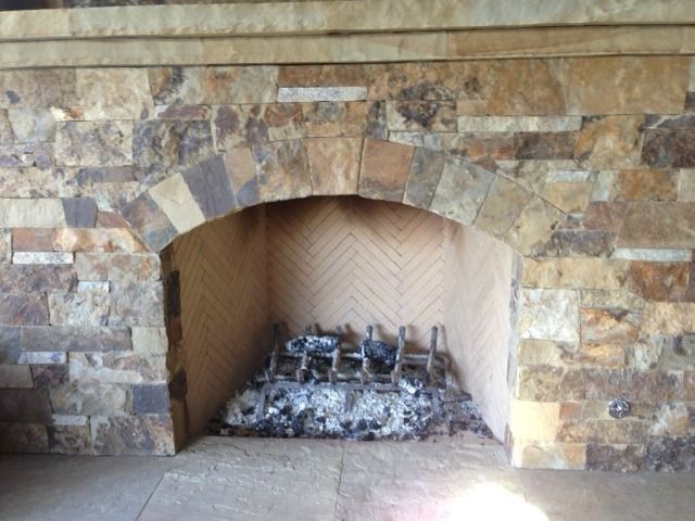 A fireplace with a stone wall surrounding it
