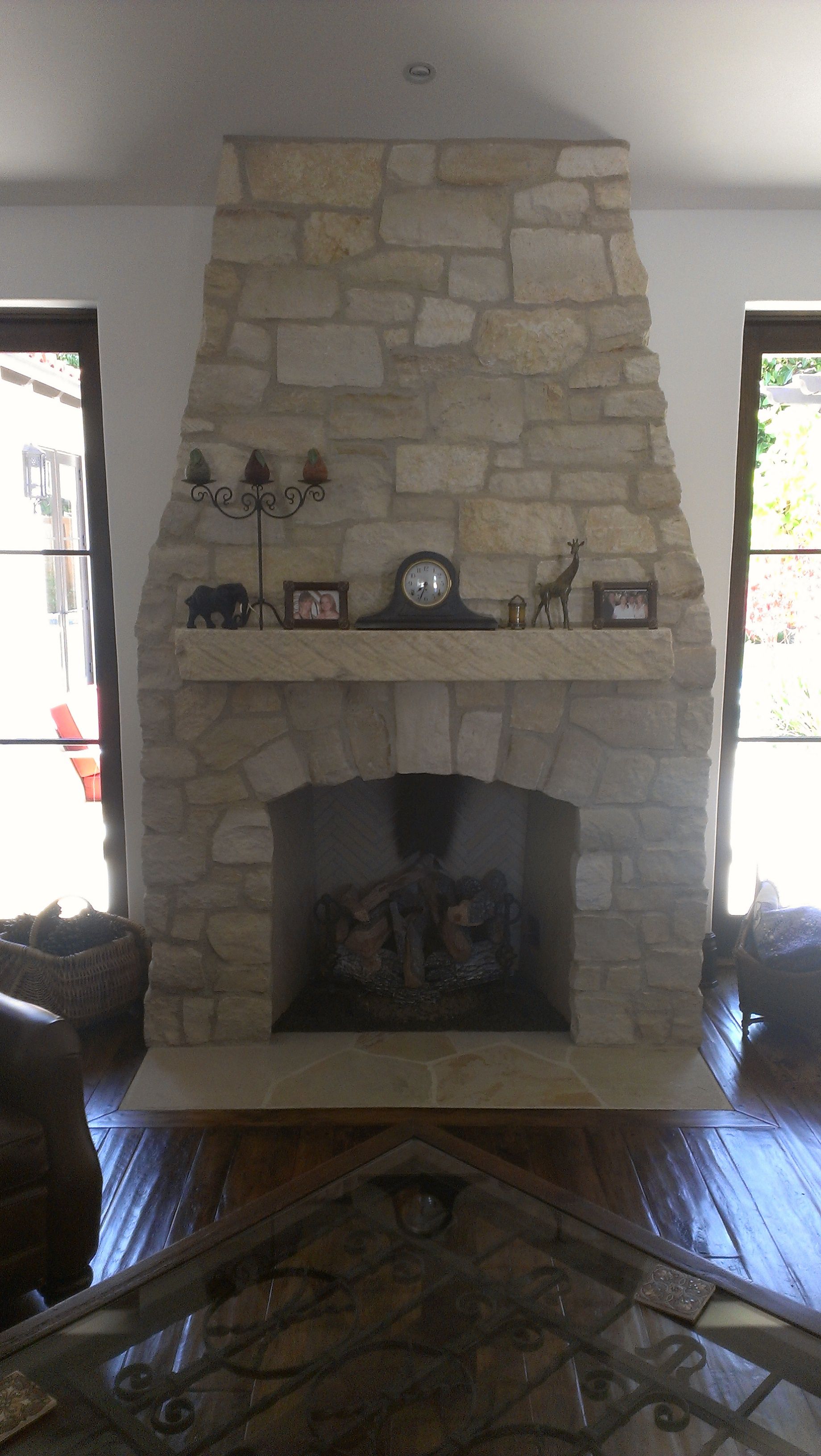 A living room with a fireplace and a clock on the mantle.