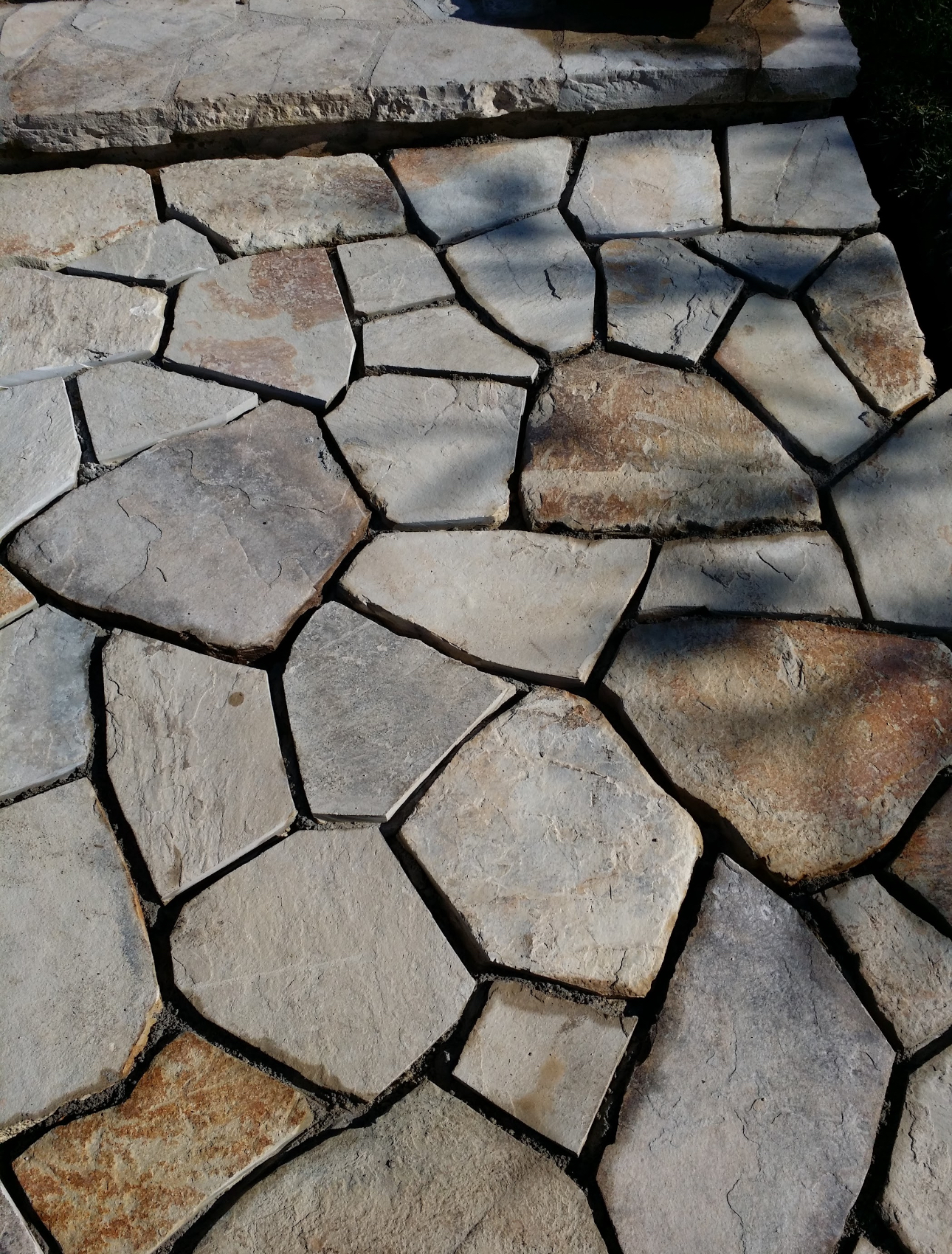 A stone walkway with a lot of different shaped stones