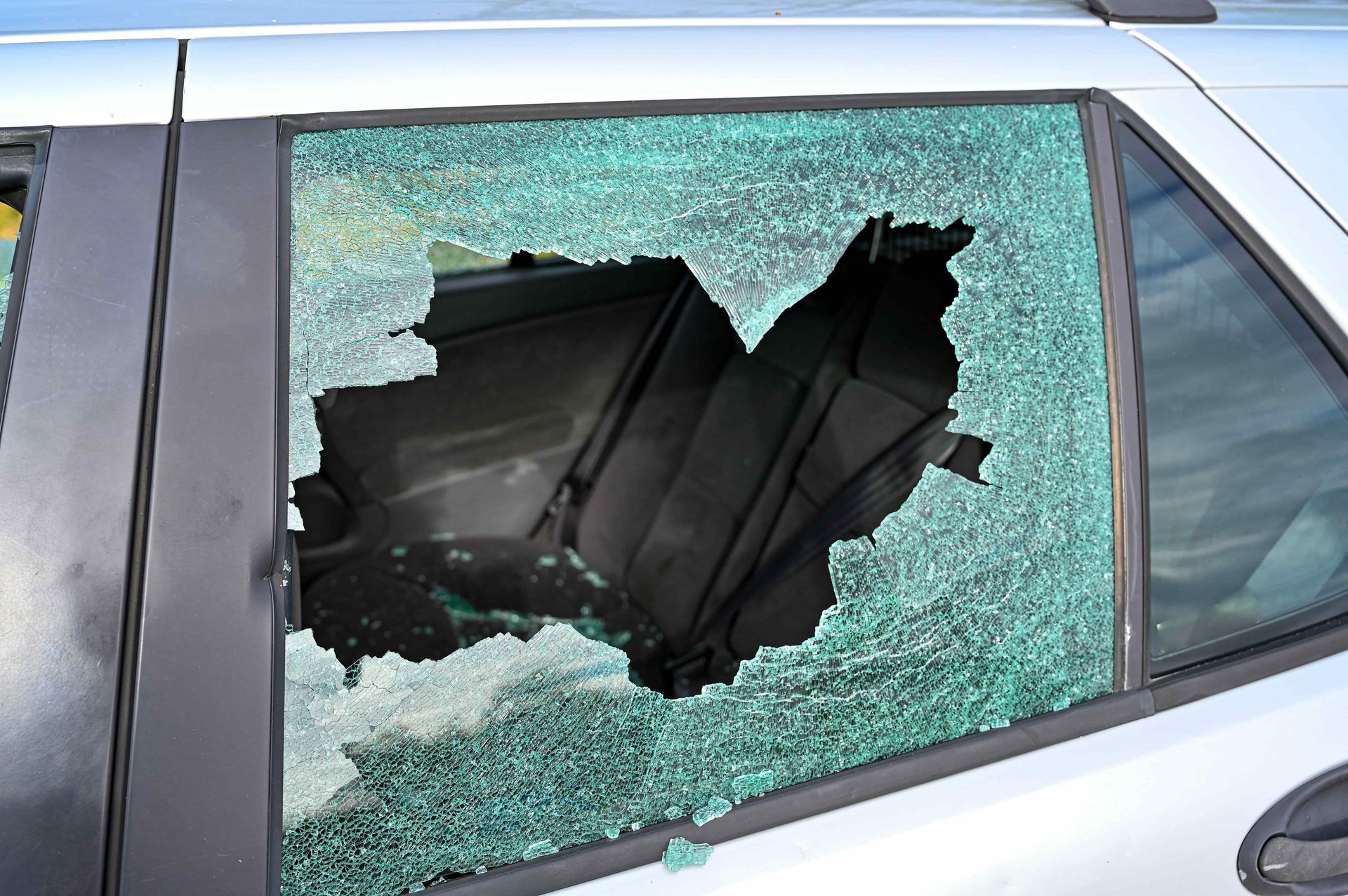 Car window shattered with a large hole in the glass.