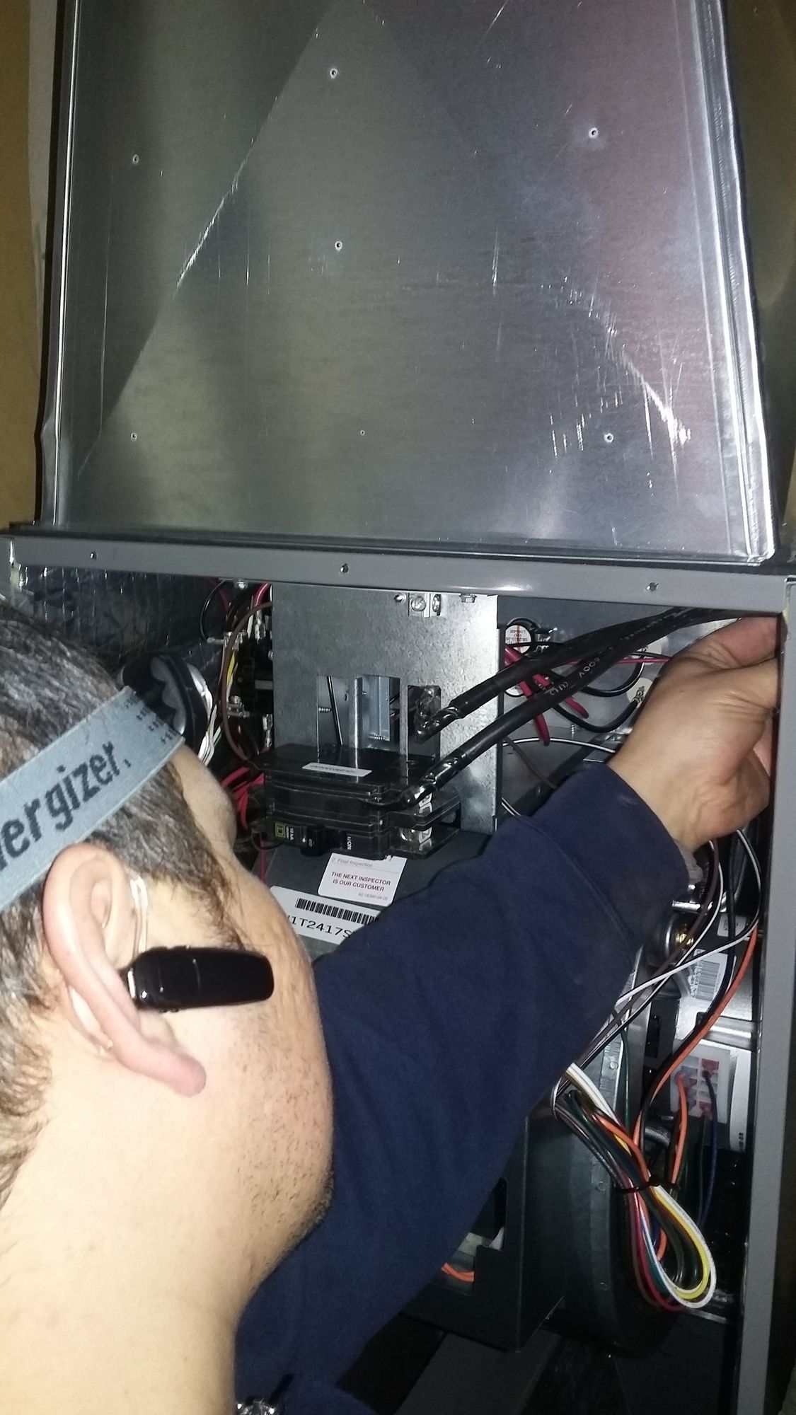 A man wearing a headband that says energizer is working on a computer.