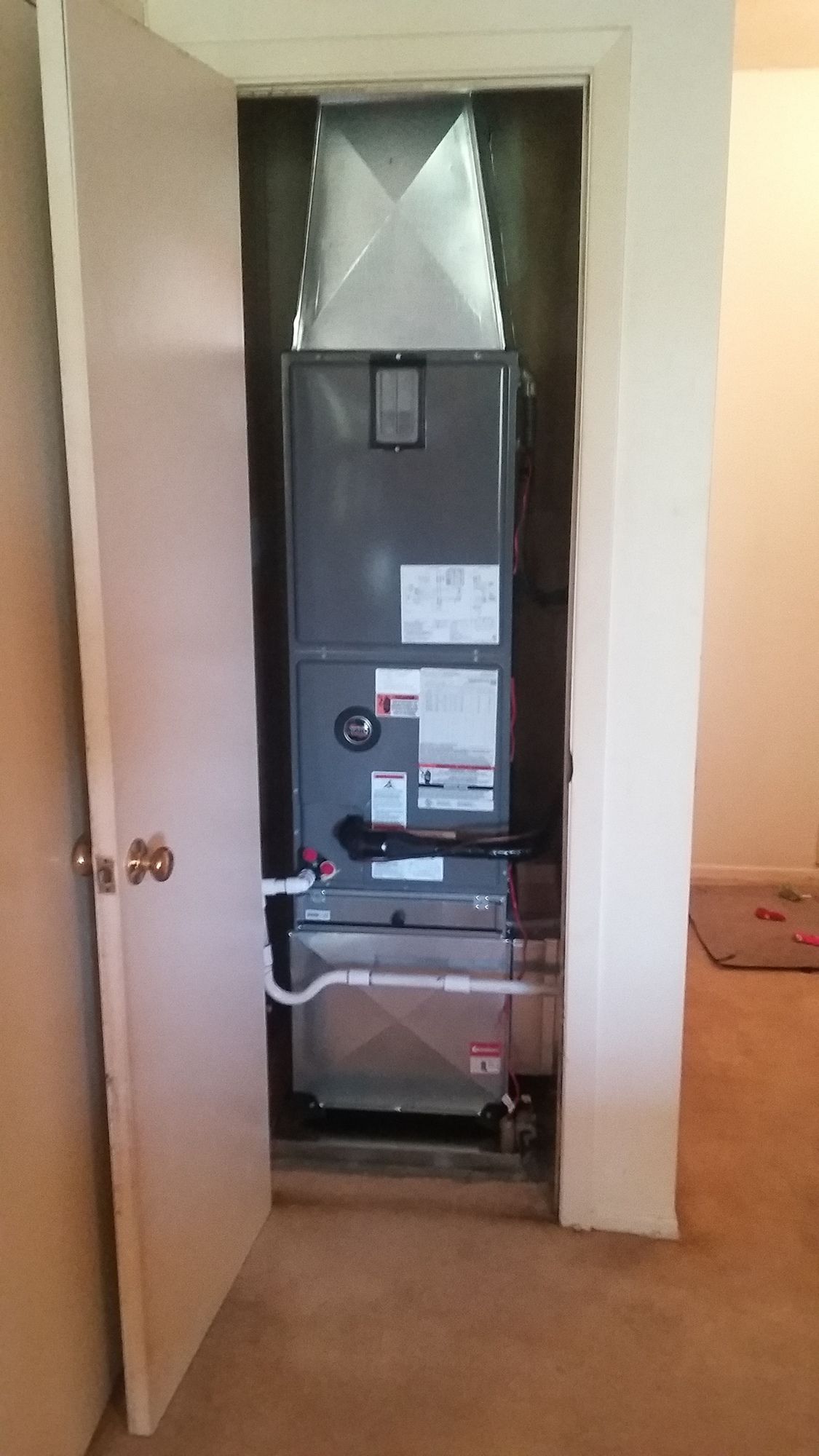 An air conditioner is installed in a closet in a room.