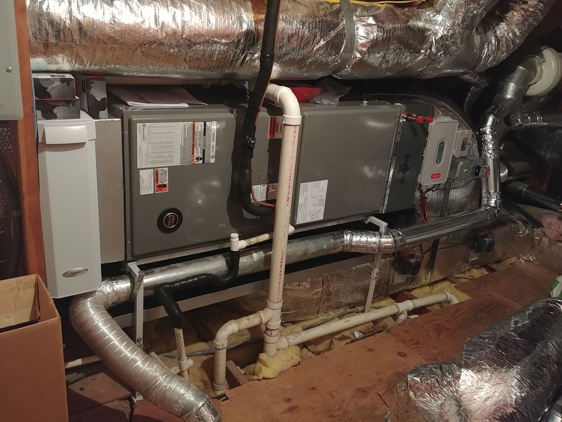 A room with a lot of pipes and a box on the floor.