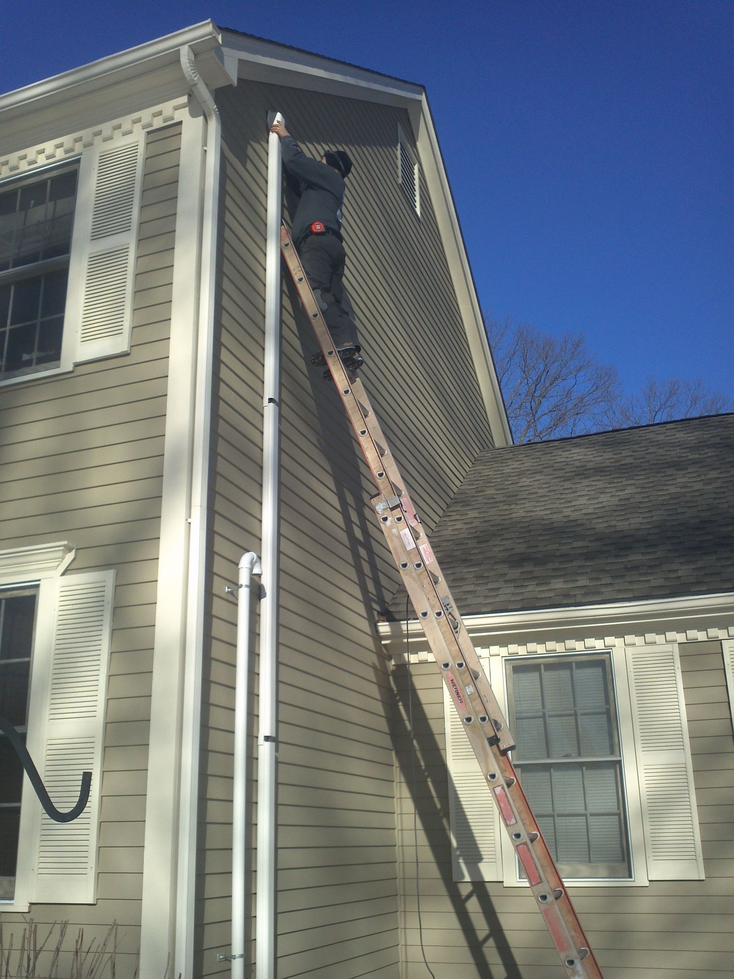 A man on a ladder on the side of a house