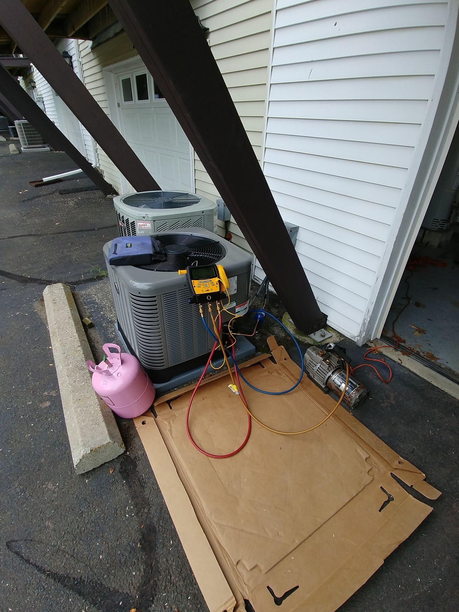 An air conditioner is being repaired on the side of a building