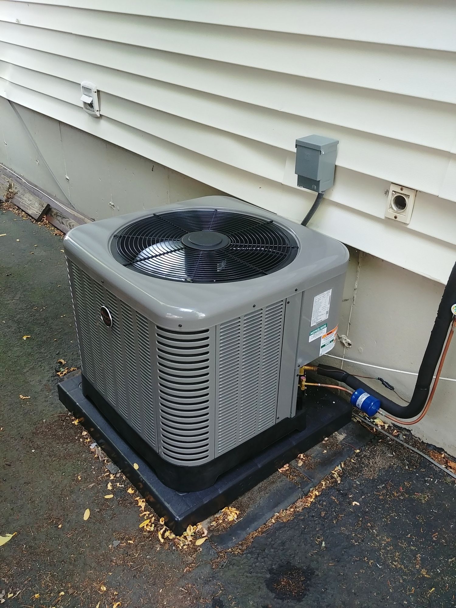 An air conditioner is sitting on the side of a house.