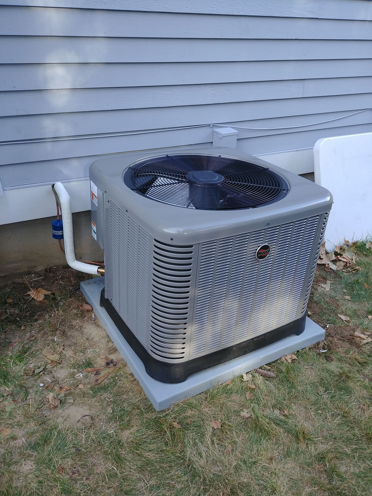 An air conditioner is sitting on the side of a house.