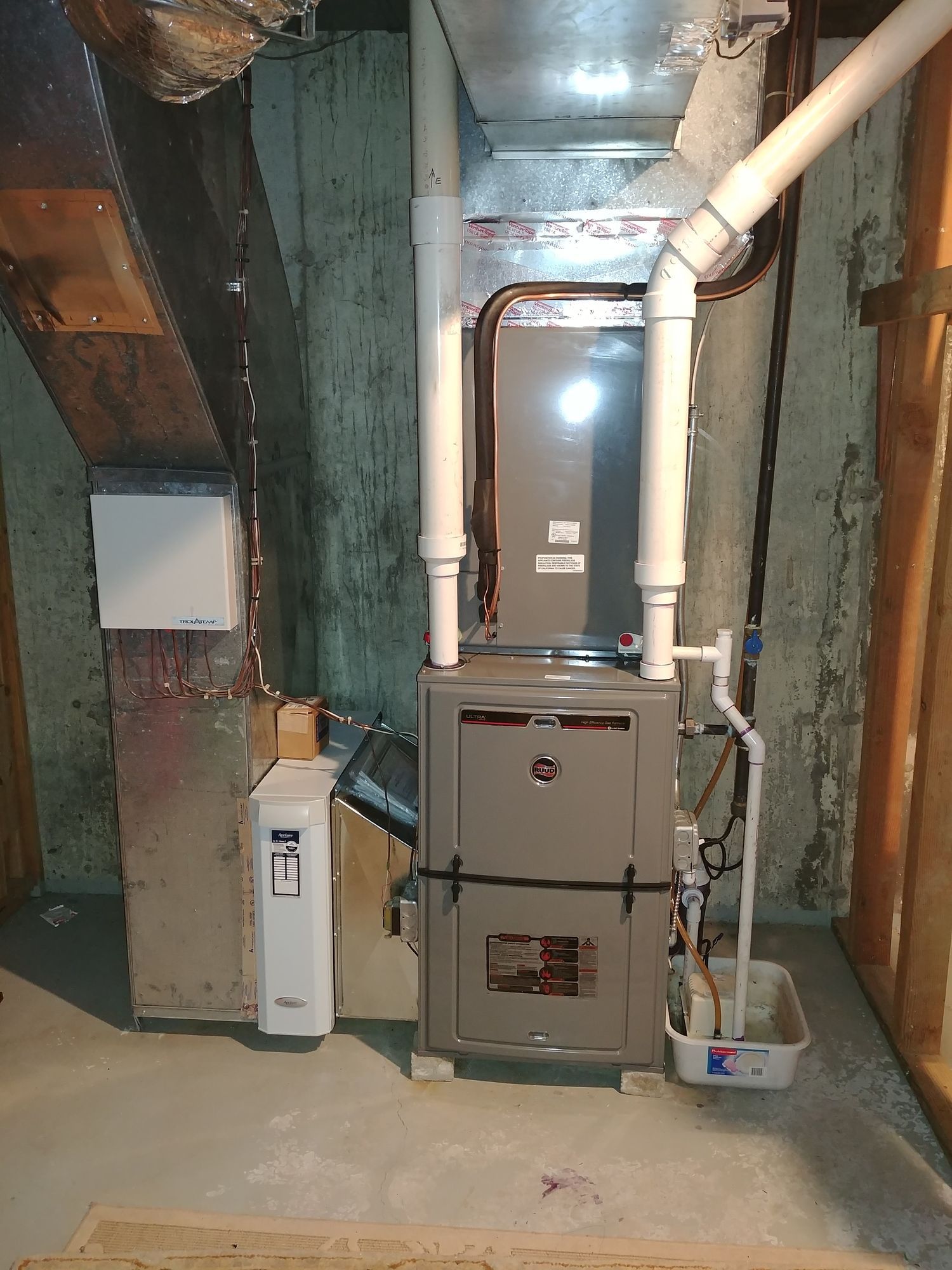 A basement with a furnace and a water heater.