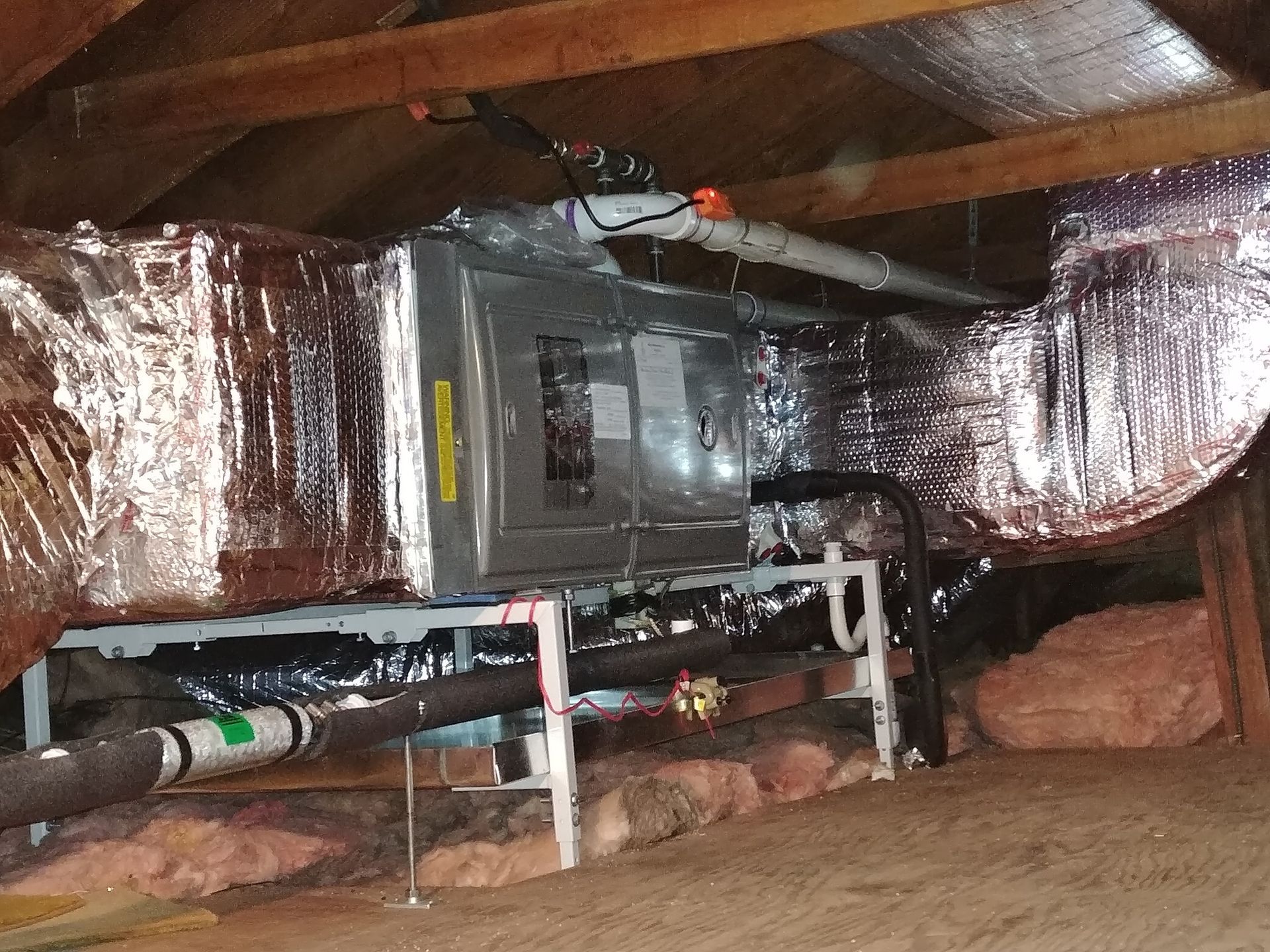 An air conditioner is installed in the attic of a house.