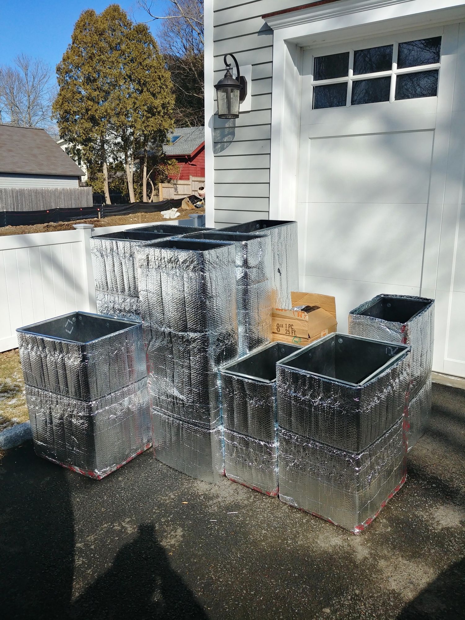 A bunch of metal boxes are sitting in front of a garage door.
