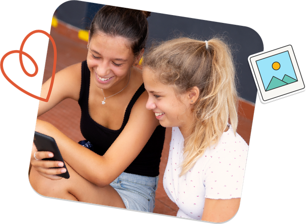 Two teen girls are sitting next to each other looking at a cell phone.