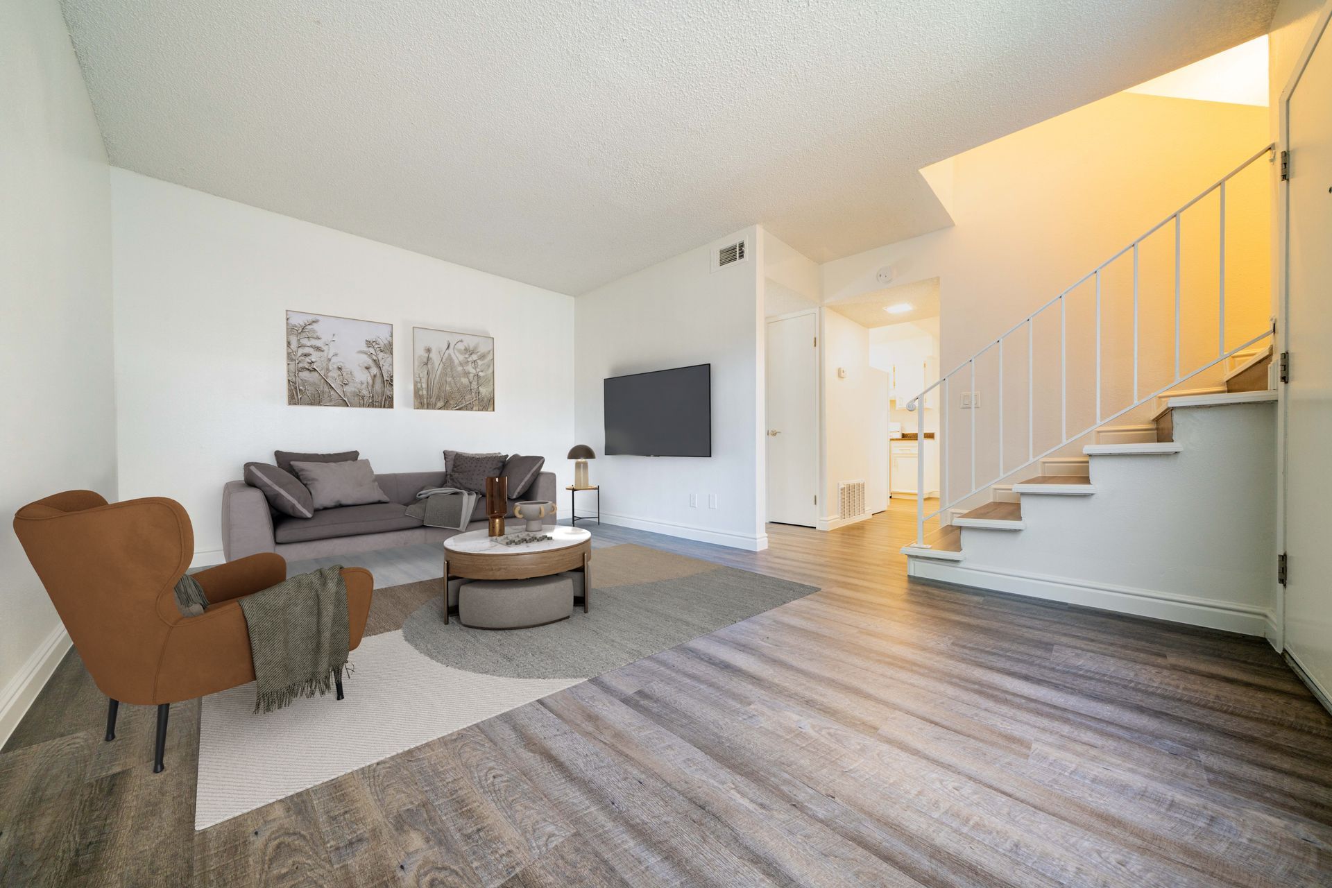 unfurnished living area with stairs and a view into the bedroom