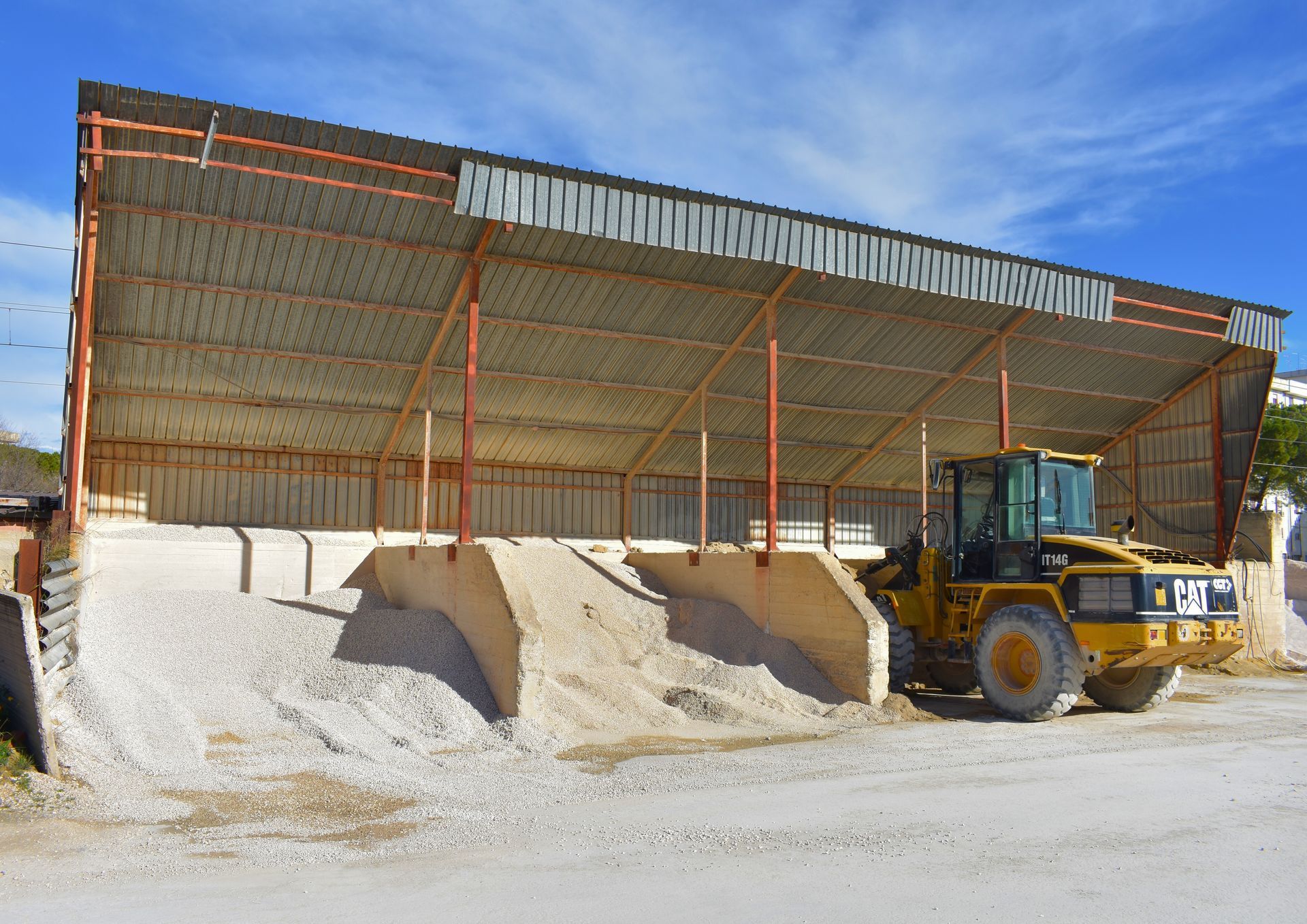 Un bulldozer giallo è parcheggiato davanti a un edificio edil 2000 lucera