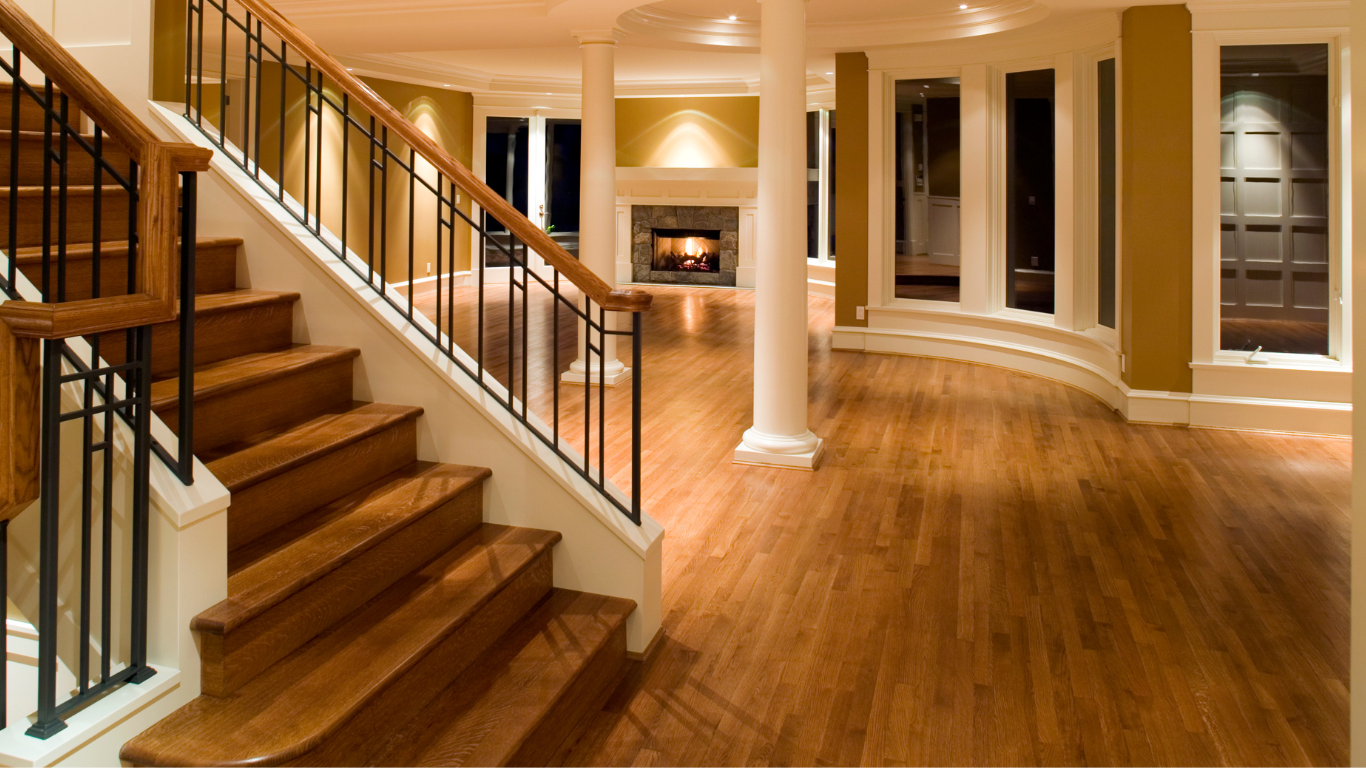 Living room with fireplace, dark blue accent wall, chandelier, wood flooring.