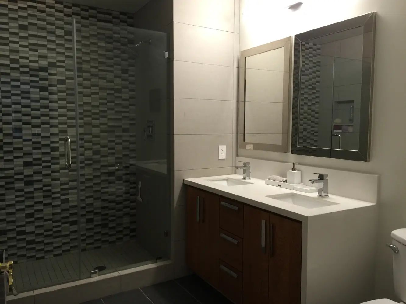 Modern white bathroom with large soaking tub, walk-in shower, double vanity, and natural light from windows.
