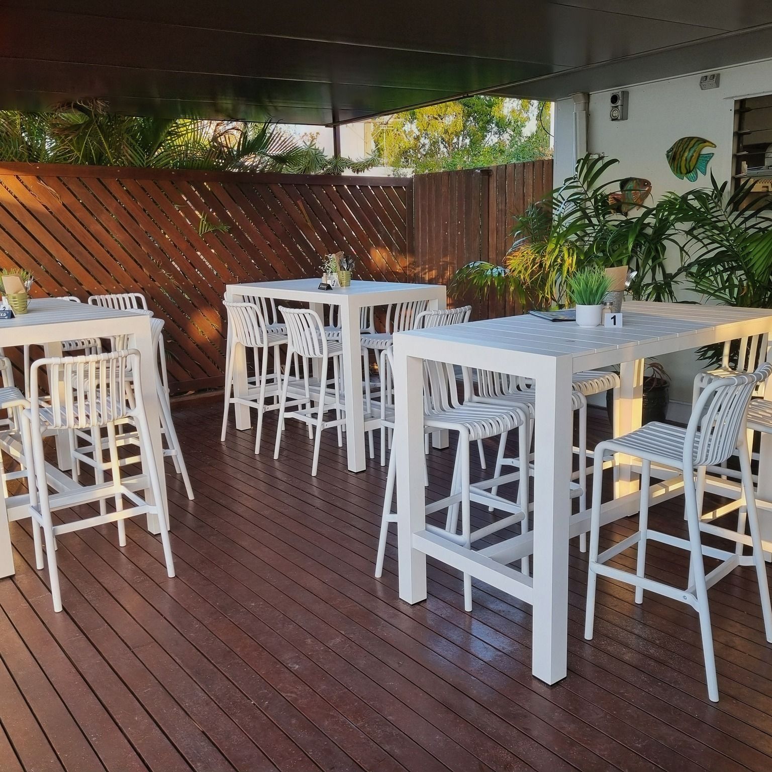 Outdoor Patio With White Tables and Chairs — The Beach Bar and Restaurant at Montes in Whitsundays, QLD