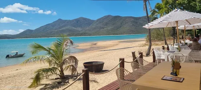 Beachside restaurant with tables and umbrellas — The Beach Bar and Restaurant at Montes in Cape Gloucester, QLD